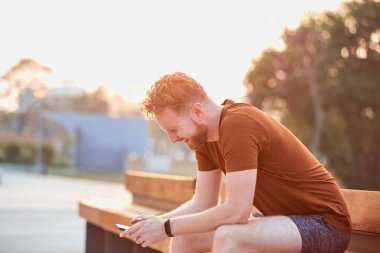 Yazın şehir bölgesinde cep telefonu kullanan bir adam.