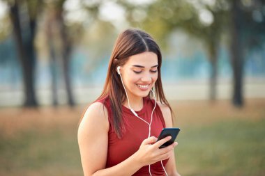 Cep telefonlu modern genç kadın koşu / egzersiz sırasında mola veriyor.