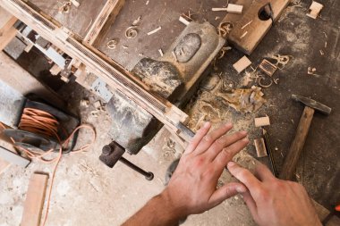 Erkek marangoz antika bir atölyede eski ahşap üzerinde çalışıyor..