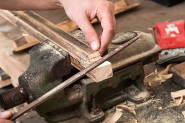 Erkek marangoz antika bir atölyede eski ahşap üzerinde çalışıyor..