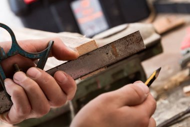 Erkek marangoz antika bir atölyede eski ahşap üzerinde çalışıyor..