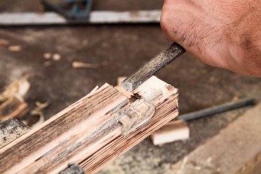 Erkek marangoz antika bir atölyede eski ahşap üzerinde çalışıyor..