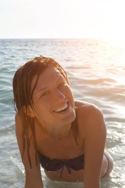 Yazın okyanus / deniz suyunda eğlenen genç bir kadın..