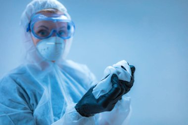 Tıbbi doktor, dezenfeksiyon için antiseptik doku taşıyan virüslerden ve hastalıklardan korunmak için giysi giyen bilim adamı..