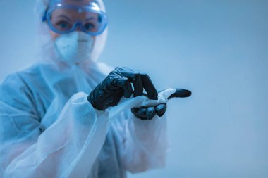 Tıbbi doktor, dezenfeksiyon için antiseptik doku taşıyan virüslerden ve hastalıklardan korunmak için giysi giyen bilim adamı..