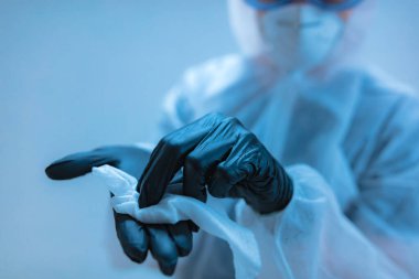Tıbbi doktor, dezenfeksiyon için antiseptik doku taşıyan virüslerden ve hastalıklardan korunmak için giysi giyen bilim adamı..