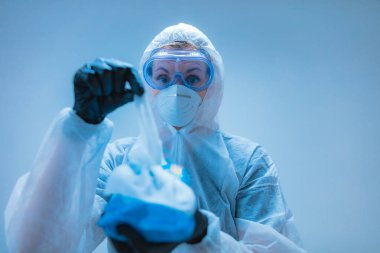 Tıbbi doktor, dezenfeksiyon için antiseptik doku taşıyan virüslerden ve hastalıklardan korunmak için giysi giyen bilim adamı..