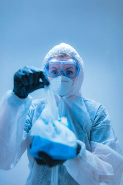 Tıbbi doktor, dezenfeksiyon için antiseptik doku taşıyan virüslerden ve hastalıklardan korunmak için giysi giyen bilim adamı..