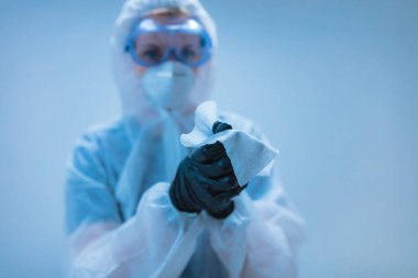 Tıbbi doktor, dezenfeksiyon için antiseptik doku taşıyan virüslerden ve hastalıklardan korunmak için giysi giyen bilim adamı..