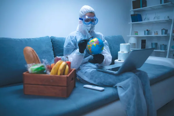 Quarantine and isolation during the virus outbreak - groceries and food in stock, working from home over the internet, holding globe map.