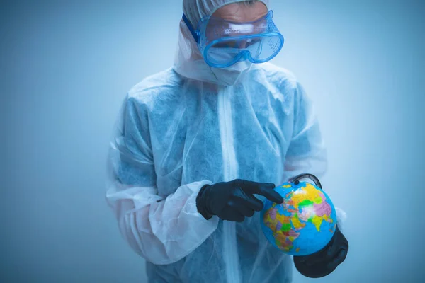 Medical doctor and scientist holding Earth globe for presenting virus pandemic outbreak on the whole planet.