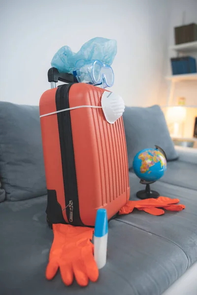 旅行袋手提箱 装有地球仪 面罩和头罩 以防止感染病毒和流感 到世界各地旅游都被取消了 2020年的旅游旺季推迟了 — 图库照片