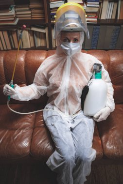 Koruyucu antiviral maskeli kişi, kimyasal dezenfekte spreyi şişesi ev izolasyonunda..