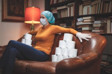 Woman with protective antiviral mask and a reserve of toilet paper waiting anxious in home isolation. clipart