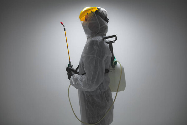 Scientist holding chemical sprayer for sterilization and decontamination of viruses, germs, pests, infectious diseases.