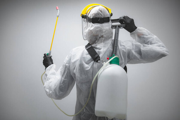 Scientist holding chemical sprayer for sterilization and decontamination of viruses, germs, pests, infectious diseases.