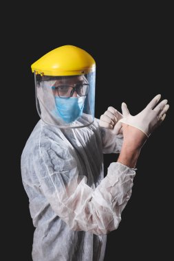 Tıp doktoru, hemşire, cerrah, koruyucu maske, gözlük ve eldivenlerle çalışan psikolog panik, salgın ve siyah arka planda çekim yapan insanlara yardım ediyor..