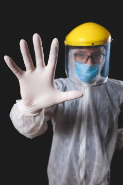 Tıp doktoru, hemşire, cerrah, koruyucu maske, gözlük ve eldivenlerle çalışan psikolog panik, salgın ve siyah arka planda çekim yapan insanlara yardım ediyor..
