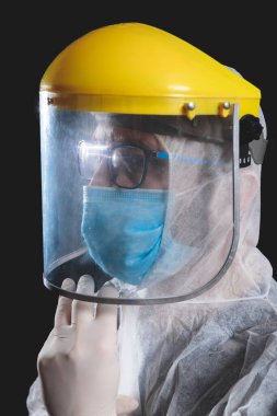 Tıp doktoru, hemşire, cerrah, koruyucu maske, gözlük ve eldivenlerle çalışan psikolog panik, salgın ve siyah arka planda çekim yapan insanlara yardım ediyor..