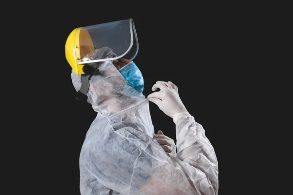 Medical doctor, nurse, surgeon, psychologist working with protective mask, glasses and gloves helping people in the days of panic, pandemic - studio shot on black background.