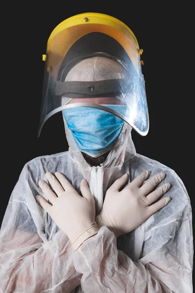 Medical doctor, nurse, surgeon, psychologist working with protective mask, glasses and gloves helping people in the days of panic, pandemic - studio shot on black background.