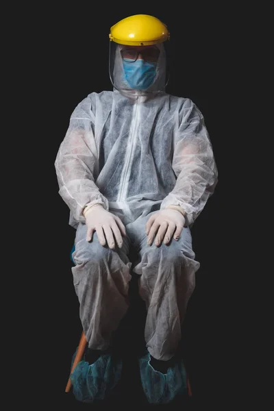 Medical doctor, nurse, surgeon, psychologist working with protective mask, glasses and gloves helping people in the days of panic, pandemic - studio shot on black background.