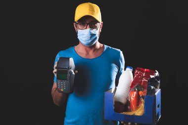 Koruyucu maskeli teslimatçı. Bakkaliye ve POS ile birlikte. Temassız ödeme için..