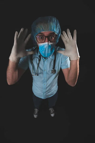 Medical doctor, nurse, surgeon, psychologist working with protective mask, glasses and gloves helping people in the days of panic, pandemic - studio shot on black background.