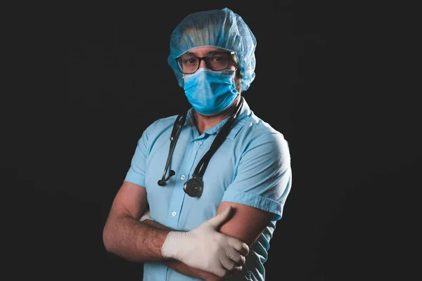 Medical doctor, nurse, surgeon, psychologist working with protective mask, glasses and gloves helping people in the days of panic, pandemic - studio shot on black background.