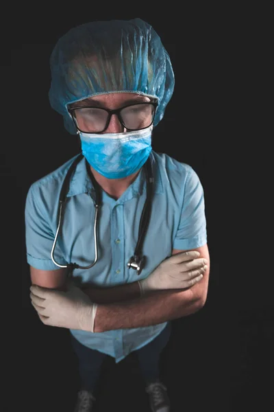 Medical doctor, nurse, surgeon, psychologist working with protective mask, glasses and gloves helping people in the days of panic, pandemic - studio shot on black background.