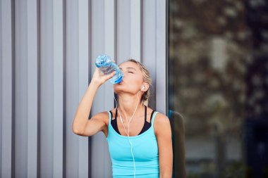 Kentsel alanda koştuktan sonra modern sporcu kadın durakladı.