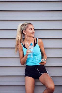 Kentsel alanda koştuktan sonra modern sporcu kadın durakladı.