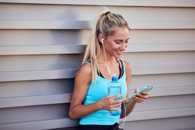 Kentsel alanda koştuktan sonra modern sporcu kadın durakladı.