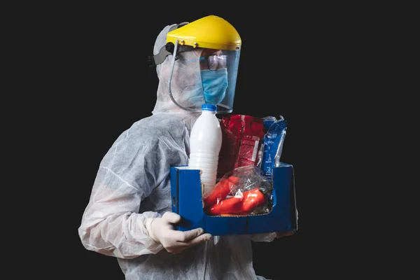 食料品や食料品の宅配 パンデミックの発生ヒステリー 完全な保護スーツの人供給と箱を保持する制服 — ストック写真