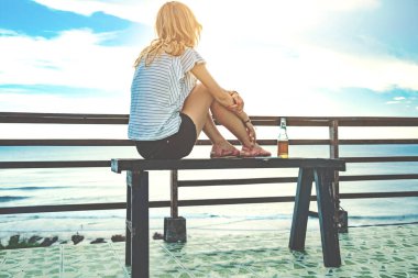 Bira içmenin ve tatilde deniz manzarasına bakmanın tadını çıkarıyorum..