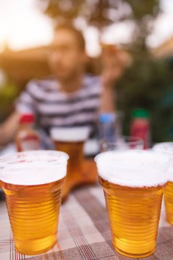 Elinde soğuk bira bardağı tutan bir adam..