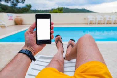 Yüzme havuzuyakınında cep telefonu kullanan adam.