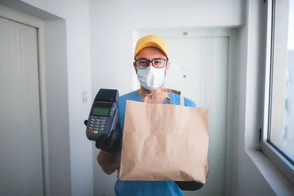 非接触決済のための食料品やPosと保護マスク保持ボックス バッグ付き配達男 — ストック写真