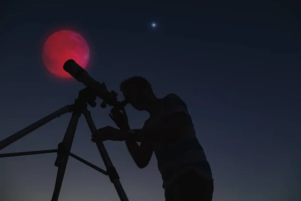 Silhouette of a man and telescope with Moon and stars.