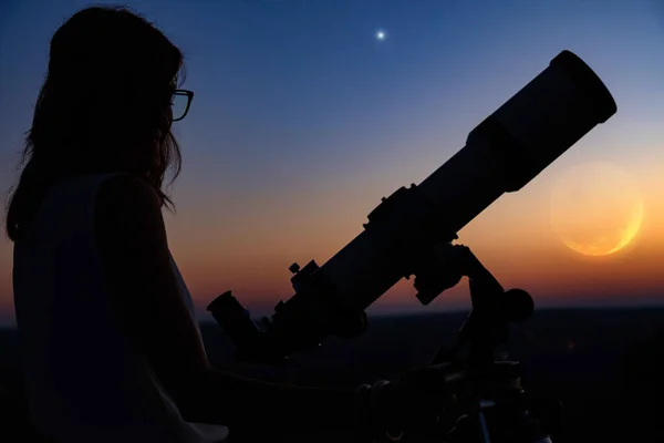 一个女人的轮廓和带着暮色天空的望远镜 — 图库照片