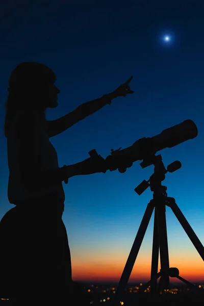 一个女人的轮廓和带着暮色天空的望远镜 — 图库照片