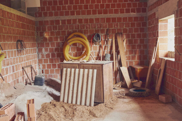 Дом в процессе реконструкции с кирпичом, песком и другими материалами
.