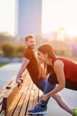 Spor çifti gün batımında ve gün doğumunda kentsel alanda egzersiz yapıyor.