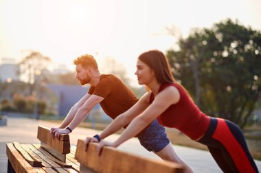Spor çifti gün batımında ve gün doğumunda kentsel alanda egzersiz yapıyor.