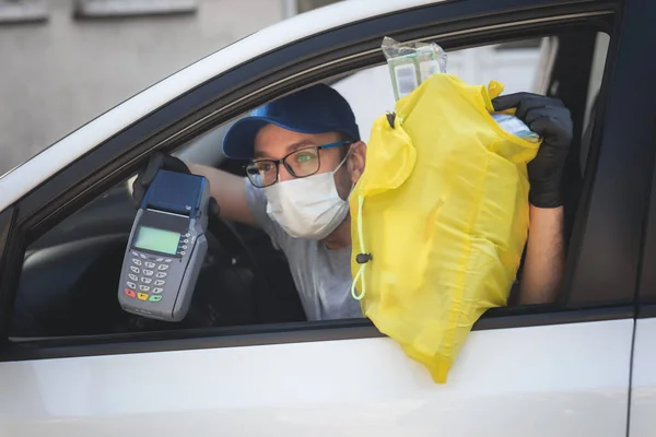 Delivery guy with protective mask and gloves delovering groceries during lockdown and pandemic.