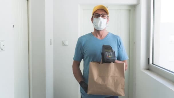 送货员带着防护面罩 拿着装有杂货和非接触式付款的盒子 — 图库视频影像