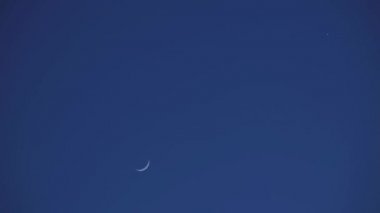 Genç Ay ve Venüs karanlık bir gece gökyüzünde. Karanlık bir gökyüzünde bu gece görülebilen uydu izleri var..