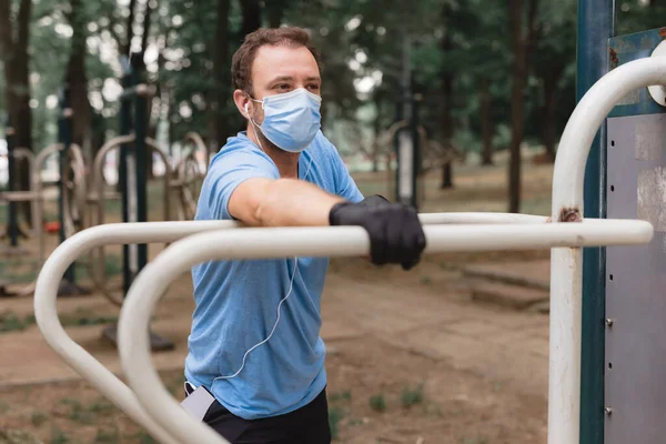 Sportman Met Medisch Masker Handschoenen Smartphone Oordopjes Aan Het Trainen — Stockfoto