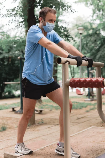 Deportista Con Máscara Médica Guantes Smartphone Auriculares Trabajando Trotando Entorno —  Fotos de Stock