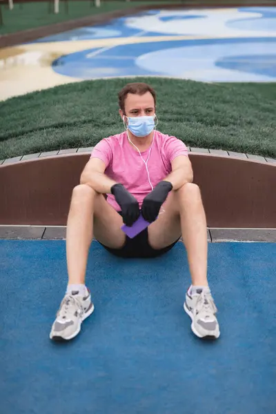 Sportman Met Medisch Masker Handschoenen Smartphone Oordopjes Aan Het Trainen — Stockfoto